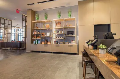 a lobby with a desk and shelves with plants on them at Canopy By Hilton Jersey City Arts District in Jersey City