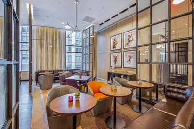 a restaurant with tables and chairs and windows at Canopy By Hilton Jersey City Arts District in Jersey City