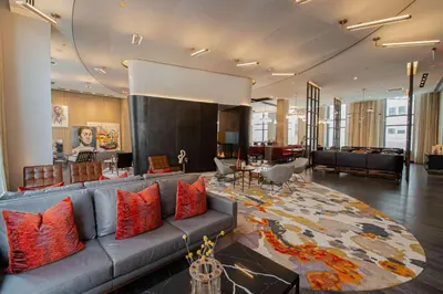a living room with a couch and a large rug at Canopy By Hilton Jersey City Arts District in Jersey City