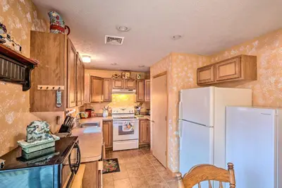 a kitchen with a white refrigerator and wooden cabinets at Walk to Pool and Lake Albrightsville Vacation Home! in Albrightsville
