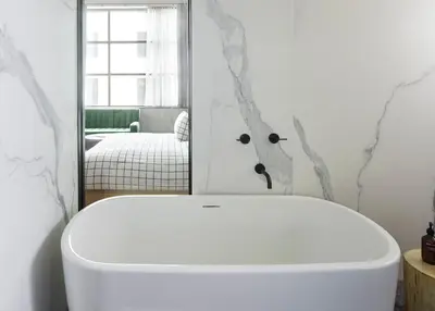 a bathroom with a white tub in front of a mirror at Fitler Club in Philadelphia