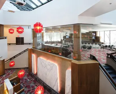 a lobby with a restaurant with red chandeliers at Crowne Plaza Princeton - Conference Center by IHG in Princeton