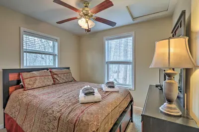 a bedroom with a bed with a ceiling fan and a lamp at 6 Mi to Skiing Family Poconos Home w Decks! in Albrightsville