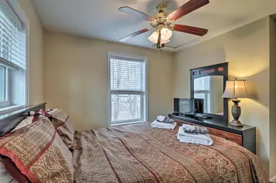 a bedroom with a bed with a ceiling fan and a mirror at 6 Mi to Skiing Family Poconos Home w Decks! in Albrightsville