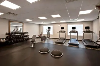 a gym with several treadmills and machines in a room at Hampton Inn & Suites Deptford, Nj in Deptford