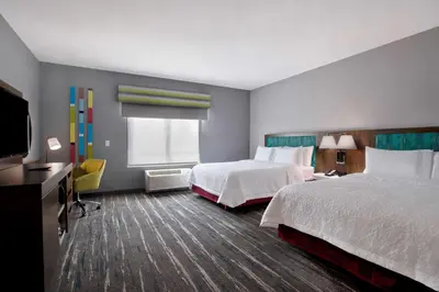 a hotel room with two beds and a flat screen tv at Hampton Inn & Suites Deptford, Nj in Deptford