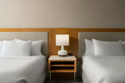 a hotel room with two beds and a lamp on a night stand at SpringHill Suites by Marriott Voorhees Mt. Laurel/Cherry Hill in Voorhees