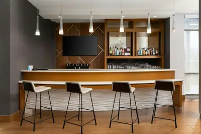 a bar with stools in a room with a tv at SpringHill Suites by Marriott Voorhees Mt. Laurel/Cherry Hill in Voorhees