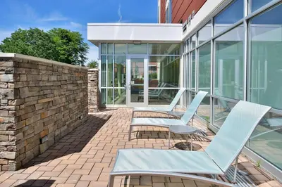 a patio with two blue chairs and a brick wall at SpringHill Suites by Marriott Voorhees Mt. Laurel/Cherry Hill in Voorhees