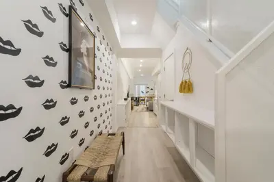 a hallway with a wall withooky faces on it at Abode XS House Stunning Architectural Flat in Philadelphia