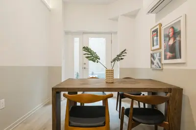 a dining room with a wooden table and chairs at Abode XS House Stunning Architectural Flat in Philadelphia