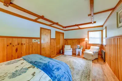 a bedroom with wooden walls and a bed in a room at Serene Home with On-Site Brook in Callicoon Center in Callicoon Center