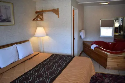 a hotel room with a bed and a bathroom at POCONO NIGHT LODGE in Bartonsville