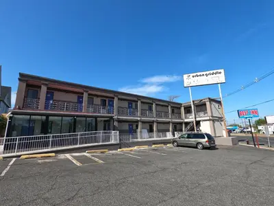 a building with a car parked in a parking lot at Rest Inn - Elizabeth in Elizabeth