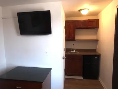a small kitchen with a flat screen tv on the wall at Rest Inn - Elizabeth in Elizabeth