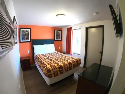 a bedroom with a bed with an orange wall at Rest Inn - Elizabeth in Elizabeth