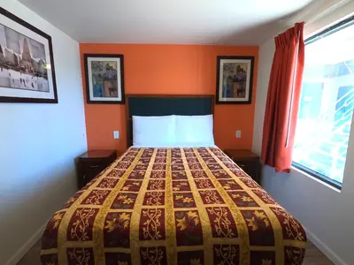 a bedroom with a bed with an orange wall at Rest Inn - Elizabeth in Elizabeth