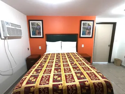a bed in a room with an orange wall at Rest Inn - Elizabeth in Elizabeth
