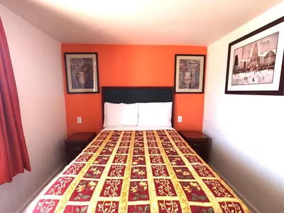 a bed in a room with an orange wall at Rest Inn - Elizabeth in Elizabeth