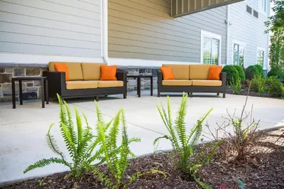 two chairs with orange pillows sitting on a patio at Courtyard by Marriott Philadelphia Springfield in Springfield