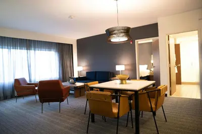 a living room with a table and chairs in a hotel room at Courtyard by Marriott Philadelphia Springfield in Springfield