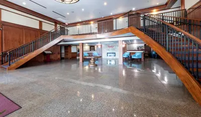 an empty lobby with a staircase in a building at HomeTowne Studios by Red Roof Wilmington - New Castle in New Castle