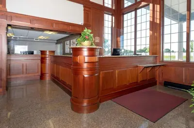 a lobby with a bar with a potted plant at HomeTowne Studios by Red Roof Wilmington - New Castle in New Castle