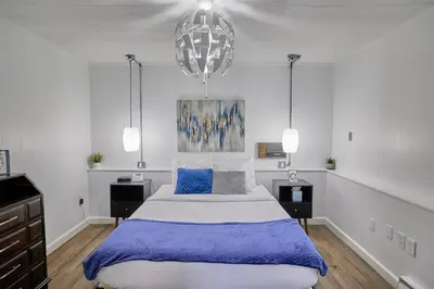 a bedroom with a large bed and a chandelier at Fairway Paradise tiny home in Lancaster