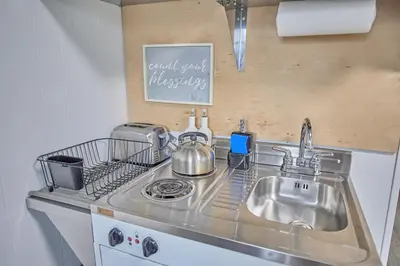 a kitchen with a sink and a stove top oven at Fairway Paradise tiny home in Lancaster