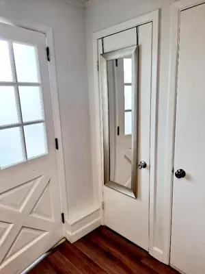 a white door with a mirror next to a window at Fairway Paradise tiny home in Lancaster
