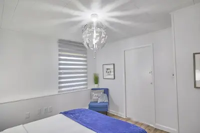 a bedroom with a bed and a chandelier at Fairway Paradise tiny home in Lancaster