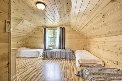 a room with three beds in a log cabin at Lake View and Hot Tub Wrightsville Cabin! in Wrightsville