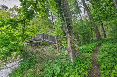 a bridge over a river in a forest at Lake View and Hot Tub Wrightsville Cabin! in Wrightsville