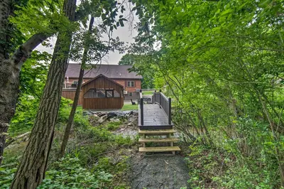 a wooden boardwalk leading to a building in the woods at Lake View and Hot Tub Wrightsville Cabin! in Wrightsville