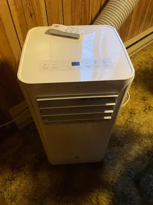 a white refrigerator with a remote on top of it at Saw Creek Cabin - Regent Hilltop in Bushkill