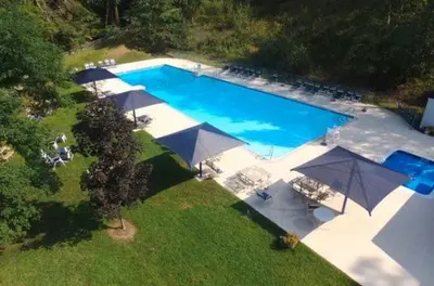 an overhead view of a large swimming pool with umbrellas at Saw Creek Cabin - Regent Hilltop in Bushkill