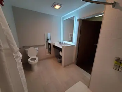 a bathroom with a toilet and a sink and a mirror at Holiday Inn Express & Suites - Harrisburg S - Mechanicsburg by IHG in Mechanicsburg