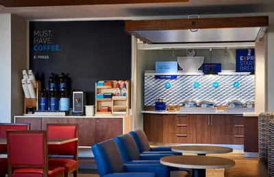 a coffee shop with blue chairs and a table at Holiday Inn Express & Suites - Harrisburg S - Mechanicsburg by IHG in Mechanicsburg