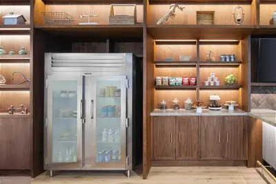 a kitchen with a refrigerator and wooden cabinets at Hyatt Centric Rittenhouse Square Philadelphia in Philadelphia
