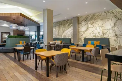 a restaurant with tables and chairs and a mural at Home2 Suites by Hilton Philadelphia Convention Center in Philadelphia