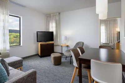 a living room with a table and chairs and a television at TownePlace Suites by Marriott York in York