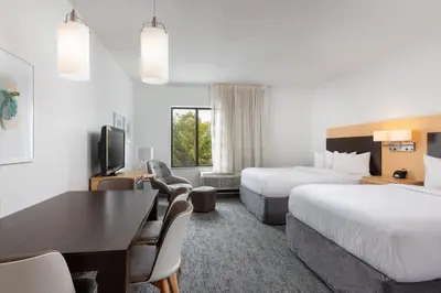 a hotel room with two beds and a desk at TownePlace Suites by Marriott York in York
