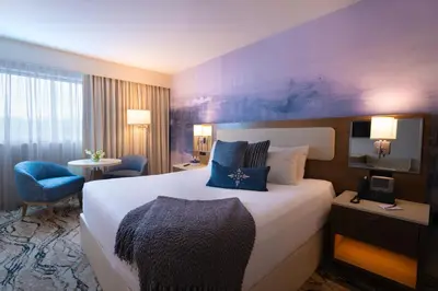 a hotel room with a large bed and a desk at Mohegan Pennsylvania Casino Resort - Adults Only in Wilkes-Barre