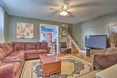 a living room with a couch and a flat screen tv at Suburban Home with Backyard Patio Less Than 7 Miles to Dtwn! in Lansdowne