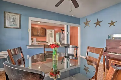 a dining room with a glass table with chairs and a piano at Suburban Home with Backyard Patio Less Than 7 Miles to Dtwn! in Lansdowne