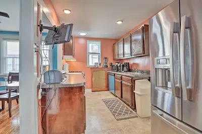 a kitchen with a stainless steel refrigerator and wooden cabinets at Suburban Home with Backyard Patio Less Than 7 Miles to Dtwn! in Lansdowne