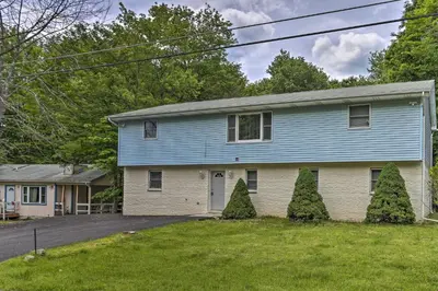 a blue house with two trees in the yard at PoolandBeach Access Spacious Tobyhanna Family Home! in Tobyhanna