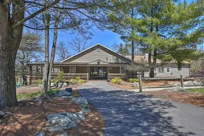 a home in the woods with a driveway at PoolandBeach Access Spacious Tobyhanna Family Home! in Tobyhanna