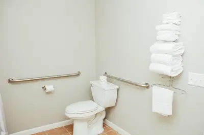 a bathroom with a toilet and towels at Country Squire Inn and Suites in New Holland