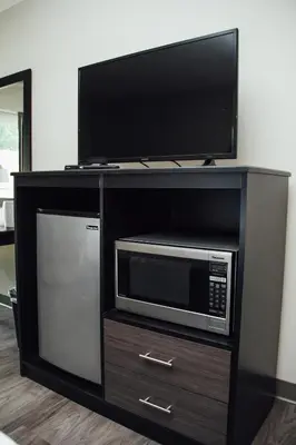 a entertainment center with a microwave and a tv at Country Squire Inn and Suites in New Holland